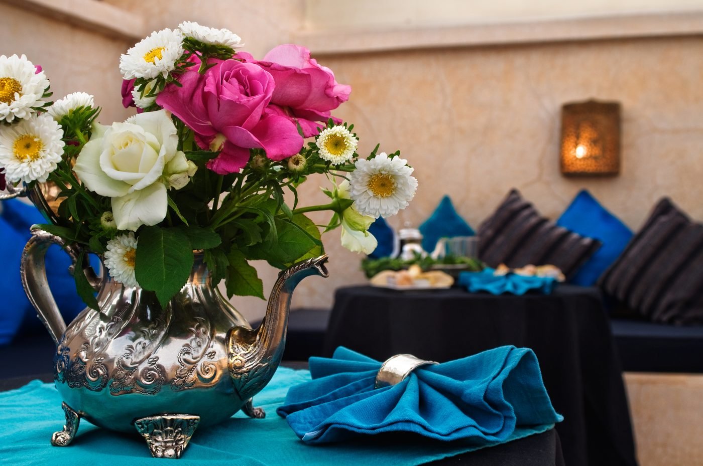 Moroccan teapot with fresh flowers on a riad terrace